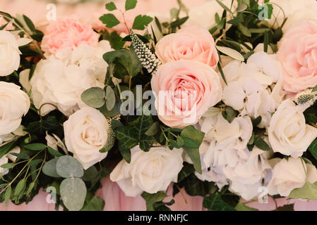 Si tratta di un sacco di fiori diversi su una tabella di nozze. La decorazione di un tavolo tessuto di colore rosa e in fiori freschi Foto Stock