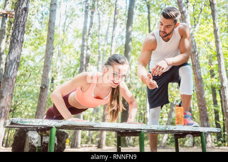 Donna sportivo facendo push-up in una palestra a cielo aperto Foto Stock