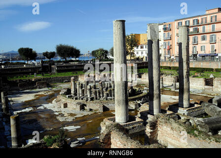 Pozzuoli, Campania, Italia. Il Macellum : era il Macellum o mercato edificio della colonia romana di Puteoli, ora la città di Pozzuoli nel sud dell'Italia. Quando per la prima volta scavate nel XVIII secolo, il ritrovamento di una statua di Serapide ha portato alla costruzione di essere identificato erroneamente come la città serapeo o Tempio di Serapide. Il Macellum è periodicamente sommerse in parte dal mare a causa del bradisismo di origine vulcanica che interessa i Campi Flegrei. Il livello raggiunto dall'acqua è visibile su colonne. I fori lasciati dai molluschi Lithophaga sono visibili anche sulle colonne. Foto Stock