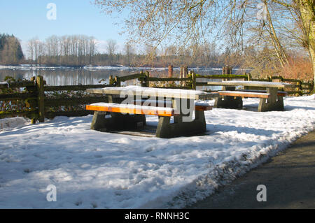 Tavoli da picnic coperto di neve. Kanaka Creek Riverfront Parco Regionale. Maple Ridge, British Columbia, Canada. Foto Stock