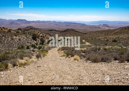 Stati Uniti d'America, Nevada, Clark County, Gold Butte National Monument. Whitney Pass strada scavalca la Vergine le montagne con il Lago Mead visibile in distanza bel Foto Stock
