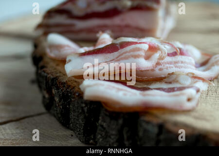 Deliziosa tutta artigianale affumicata pancetta lastra su un blocco di taglio Foto Stock