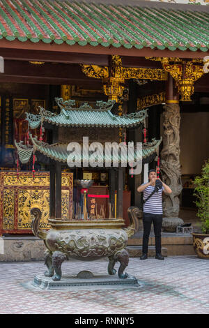 Visitatore con bastoncini di incenso nel cortile di Thian Hock Keng Tempio Taoista, Singapore. Foto Stock