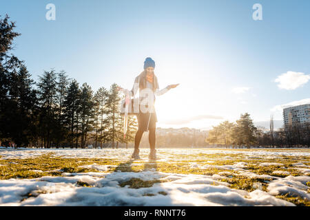 Donna che cammina attraverso il viscido neve Foto Stock