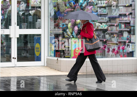 Southport, Merseyside. Xx Febbraio, 2019. Regno Unito Meteo. Bagnato e ventoso sulla costa nord-ovest come residenti e turisti prendere un immersione su windy camminare lungo il molo costiere a marea alta. Credito: MediaWorldImages/Alamy Live News Foto Stock