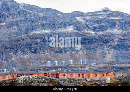 Righe colorate di moderne case Inuit tra pietre di muschio con il grigio ripidi pendii di Little Malene mountain in background, Nuuk, Groenlandia Foto Stock