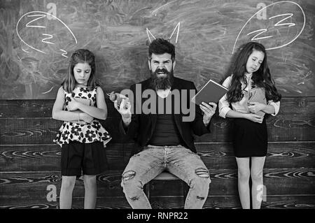 Monster insegnante gridare a sleepy alunni. L'uomo arrabbiato con sveglia e prenota. Bambine gli studenti stanchi di studio nella scuola. Tutor e studentesse Foto Stock