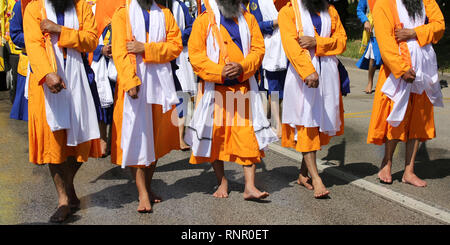 Gli uomini di religione Sikh in strada con le spade durante una parata Foto Stock