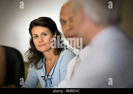 Mid-adulto business donna con i colleghi in una sala riunioni. Foto Stock