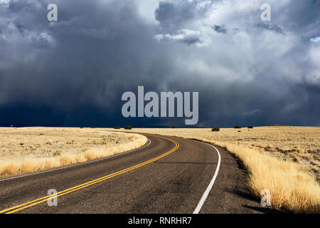 Strada che attraversa un campo di erba con spettacolari nuvole e squalls di neve nel Wupatki National Monument, Arizona, USA Foto Stock