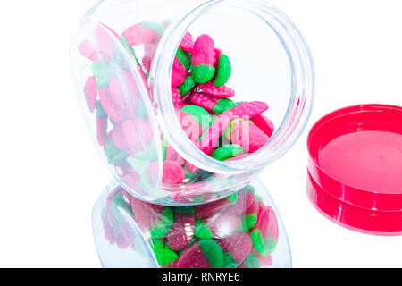 Gummy di fragole in un barattolo di caramelle su uno specchio e con sfondo Foto Stock