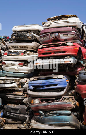 Impilati e schiacciata di automobili a un metallo di scarto riciclaggio junkyard Foto Stock