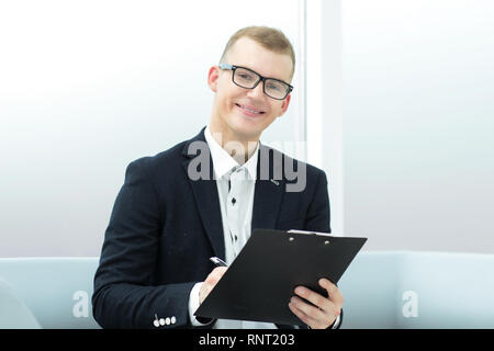 Close up. sorridente imprenditore sottoscrive un documento aziendale Foto Stock