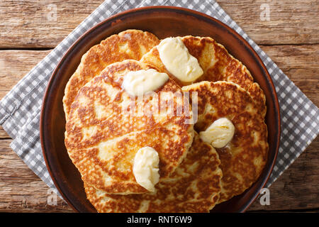 Deliziose frittelle alla griglia con burro di close-up su una piastra sul tavolo. Parte superiore orizzontale vista da sopra Foto Stock