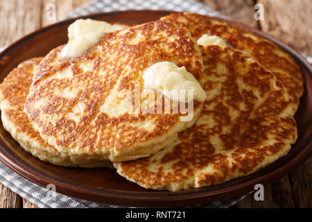 Deliziose frittelle alla griglia con burro di close-up su una piastra sul tavolo orizzontale. Foto Stock