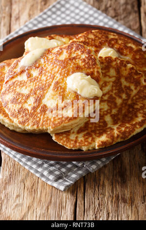 Deliziosi dolci della piastra dolci con burro di close-up su una piastra sul piano verticale. Foto Stock