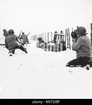 Una pattuglia, crescendo quando Lt. Thomas di cavalleria squadrone di ricognizione ha iniziato sulla neve con un fucile Granate, attacchi di cecchini tedesco scoperto nella periferia della nuova città catturate delle beffe, Belgio. Dodici Nazisti furono uccisi nell'impegno. Qui, può essere considerata parte della pattuglia avanzare con cautela attraverso la neve. Foto Stock