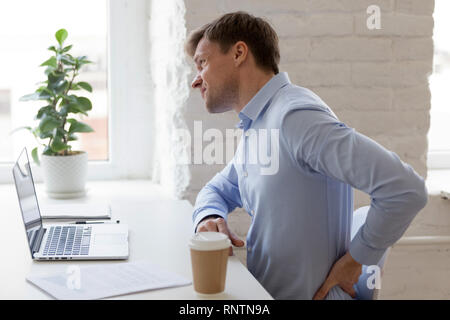 Lavoratore di ufficio avente forti dolori alla parte inferiore della schiena Foto Stock