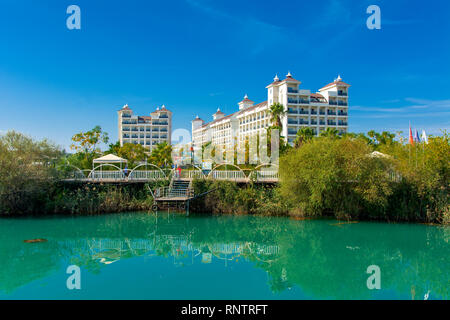 Alanya, Turchia - 05 ottobre 2018. Bellissimo hotel della Turchia contro lo sfondo delle montagne in lontananza e il cielo blu. Foto di costa dal mare. Foto Stock