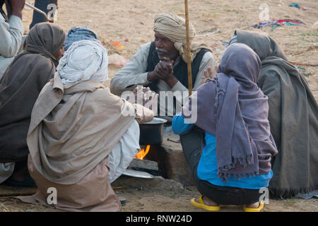 Marwari horse agricoltori sedersi attorno a un fuoco su una fredda mattina a Pushkar Camel Fair in Rajasthan, India Foto Stock