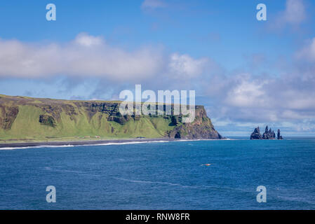 Vista dal promontorio di Dyrholaey con mare Reynisdrangar pile su sfondo in Islanda Foto Stock