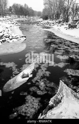 Bianco & Nero vista di neve e ghiaccio soffocato Arkansas River, che corre attraverso il quartiere del centro storico del piccolo paese di montagna di salida, Colo Foto Stock