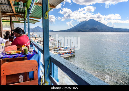 Panajachel, lago Atitlan, Guatemala - 25 dicembre 2018: ristorante sul lago il giorno di Natale a Panajachel con Atitlan & Toliman vulcani dietro. Foto Stock