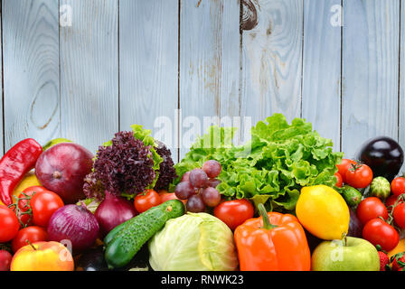 Utile la verdura e la frutta in azzurro parete in legno sfondo. Cibi sani. Foto Stock