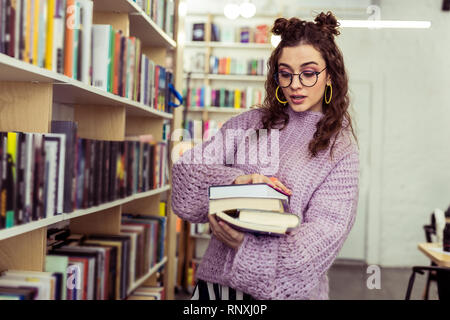 Curiosa la dama con due panini apertura libro interessati Foto Stock