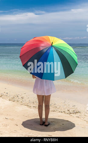 Ombrello coloratissimo lady presso la costa di Indonesia, Gili Trawangan isola. Foto Stock