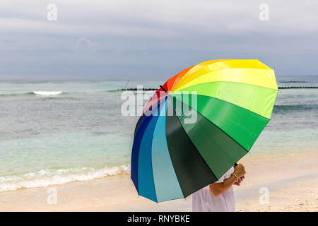 Ombrello coloratissimo lady presso la costa di Indonesia, Gili Trawangan isola. Foto Stock