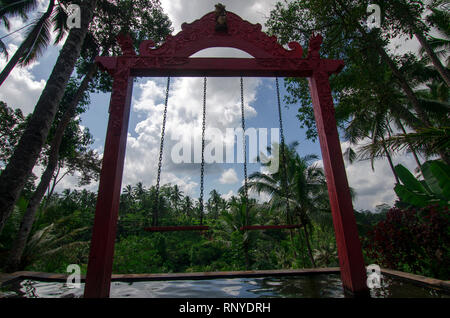 Due altalene al di sopra della piscina con un epico forest view davanti si trova nei pressi di Ubud, Gianyar, Bali, Indonesia Foto Stock