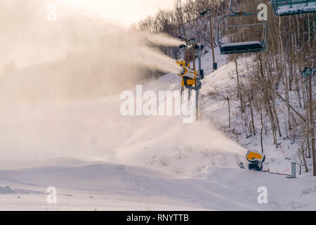 Cannoni da neve e impianti di risalita sulla montagna innevata pendenza Foto Stock