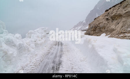 La cancellazione della strada dalla neve in montagna. Il cattivo tempo in montagna. Blizzard. Foto Stock