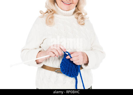 Vista ritagliata della felice senior woman standing e maglia isolato su bianco Foto Stock