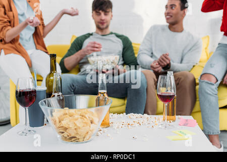 Amici multiculturale avendo divertimento fine godersi spuntini e bevande al partito di casa Foto Stock