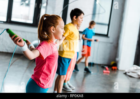 Preteen kids training con funi di salto in palestra Foto Stock