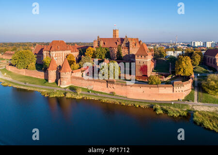 Medieval Malbork (Marienburg) castello in Polonia, fortezza principale dei Cavalieri Teutonici presso il fiume di Nogat. Vista aerea in caduta nella luce del tramonto. Foto Stock
