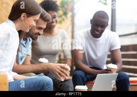 Gli amici in salotto caffetteria guardando film sul computer Foto Stock