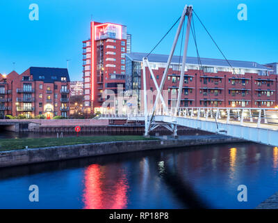 Cavalieri via Ponte sul Fiume Aire a Leeds Dock al crepuscolo Leeds West Yorkshire Inghilterra Foto Stock