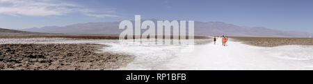 I visitatori di uscire su salina al bacino Badwater, Parco Nazionale della Valle della Morte, California, Stati Uniti. Foto Stock