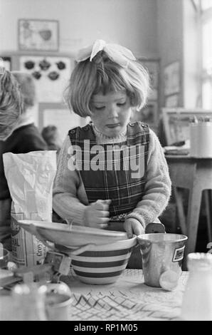 Pancake rendendo le immagini. Cinque anni di alunni da Gawthorpe neonati Scuola, Ussett, West Yorkshire, raffigurato rendendo le frittelle. Un esperimento pensato dalla direttrice Margaret Craighan. Immagine mostra Jane sottaceti string la sua miscela. La foto è stata scattata il 4° marzo 1965 Foto Stock