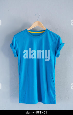 Retrò piegare in cotone blu T-Shirt vestiti mock up modello su grunge di legno bianco il concetto di sfondo per il retail dress shop sfondo, lo sbozzato piano vintage laici Foto Stock