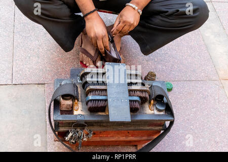 Calzolaio indiano o il comando cobbler in street officina di riparazione di calzature e di altri articoli in cuoio. Foto Stock