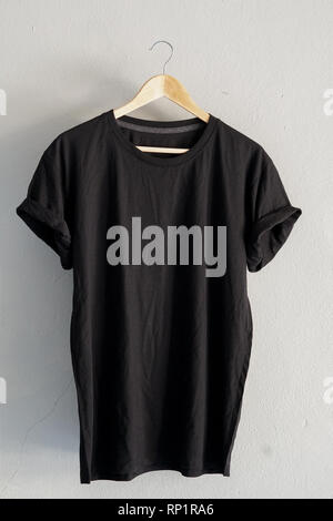 Retrò fold Black T-shirt di cotone vestiti mock up modello sul cemento grigio concetto di sfondo per il retail dress shop sullo sfondo piatto vuoto laici grigio vintage Foto Stock