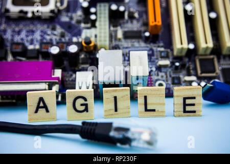 Parola agile su blocchi di legno con la tecnologia del computer mainboard sfondo. La nozione sfondo immagine Foto Stock