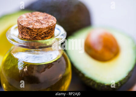 Olio di Avocado bottiglia con gli avocadi frutti, grassi sani closeup olio Foto Stock