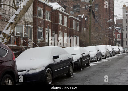 Jersey City, Stati Uniti d'America. Xx Febbraio, 2019. Accumulo di neve fresca su una linea di simile aspetto davanti a vetture di edifici su Britton Street nella città di Jersey, New Jersey, nel corso di un pomeriggio invernale nevicata nel mese di febbraio. Fatta eccezione per l'intruso - piuttosto unsnowy maroon SUV (Sport Utility Vehicle) nella parte anteriore della linea. Kay Howell/Alamy Live News Foto Stock