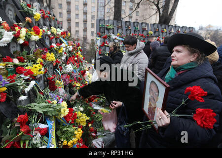 Gli ucraini sono visti immissione fiori e candele di illuminazione al memoriale di il Maidan attivisti che sono stati uccisi durante il quinto anniversario. Rivoluzione Euromaidan o rivoluzione della dignità era un ondata di dimostrazioni e disordini civili in Ucraina, che ha avuto inizio nella notte del 21 novembre 2013 con le manifestazioni di protesta in piazza Indipendenza a Kiev, chiedendo l'integrazione europea. Le proteste hanno portato al 2014 rivoluzione ucraina e la cacciata del Presidente Viktor Yanukovych. Foto Stock