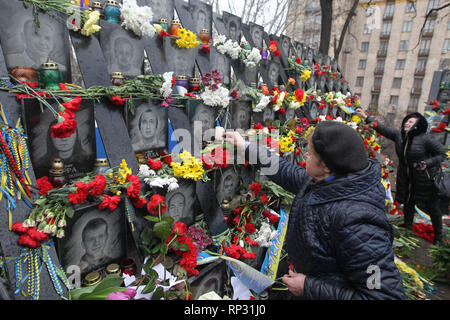 Gli ucraini sono visti immissione fiori e candele di illuminazione al memoriale di il Maidan attivisti che sono stati uccisi durante il quinto anniversario. Rivoluzione Euromaidan o rivoluzione della dignità era un ondata di dimostrazioni e disordini civili in Ucraina, che ha avuto inizio nella notte del 21 novembre 2013 con le manifestazioni di protesta in piazza Indipendenza a Kiev, chiedendo l'integrazione europea. Le proteste hanno portato al 2014 rivoluzione ucraina e la cacciata del Presidente Viktor Yanukovych. Foto Stock